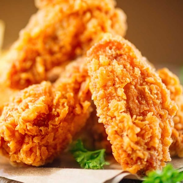 Close-up of crispy, golden-brown fried chicken pieces from CFC Fried Chicken, garnished with parsley.
